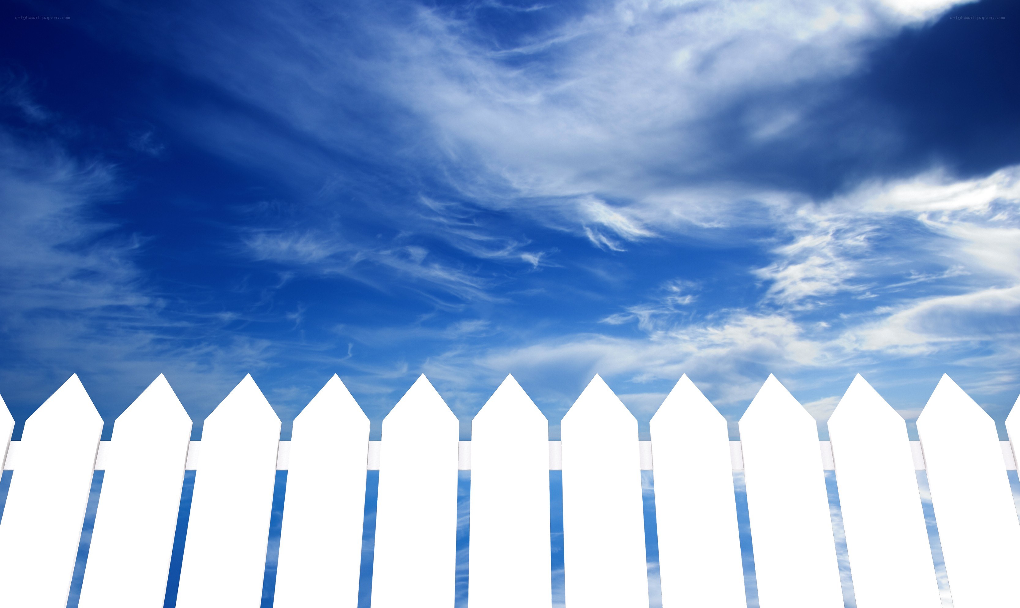 White picket fence under blue sky