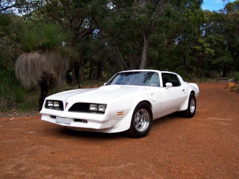 White Pontiac Firebird on dirt road