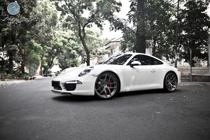 White Porsche 911 on a tree-lined street