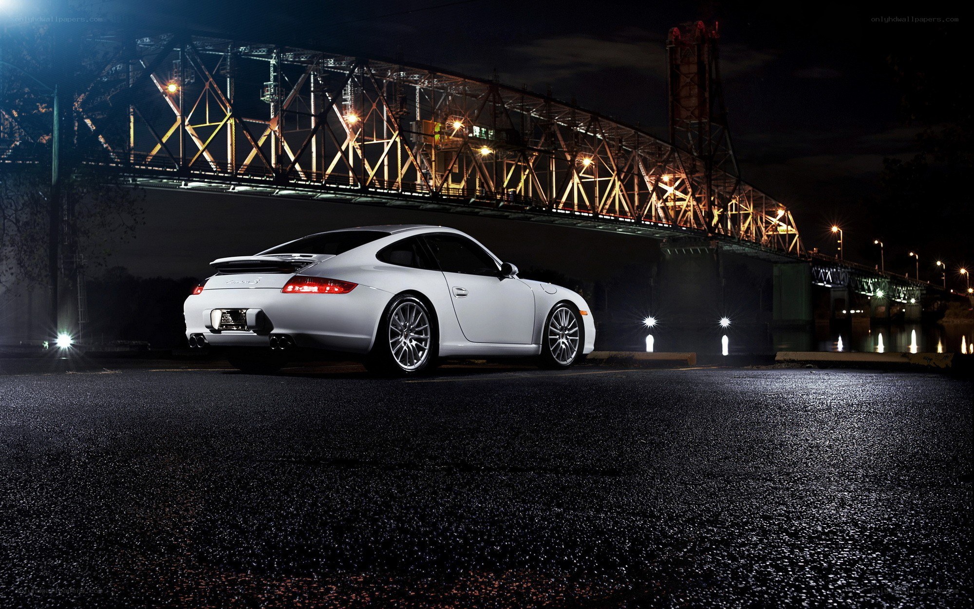 White Porsche at night under a bridge