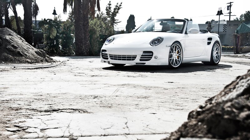 White Porsche convertible on cracked pavement