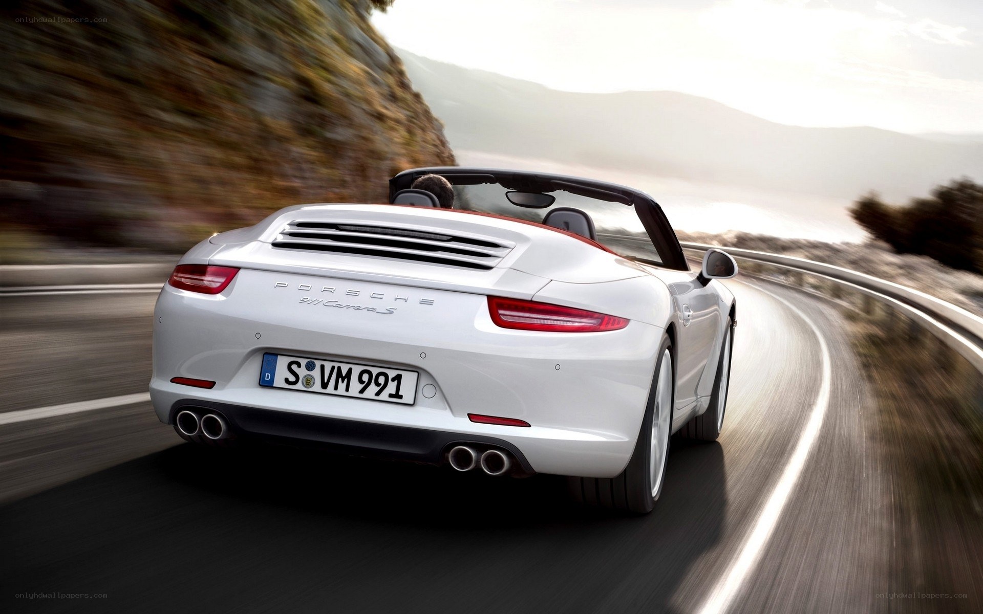 White Porsche driving on a road