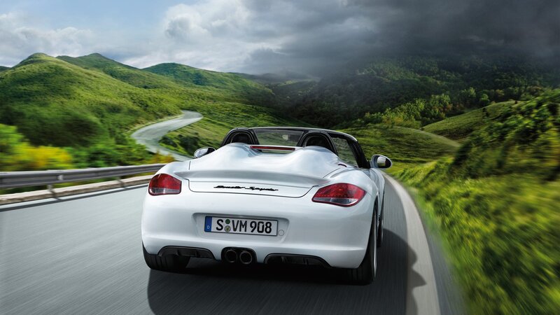 White Porsche driving on a winding road