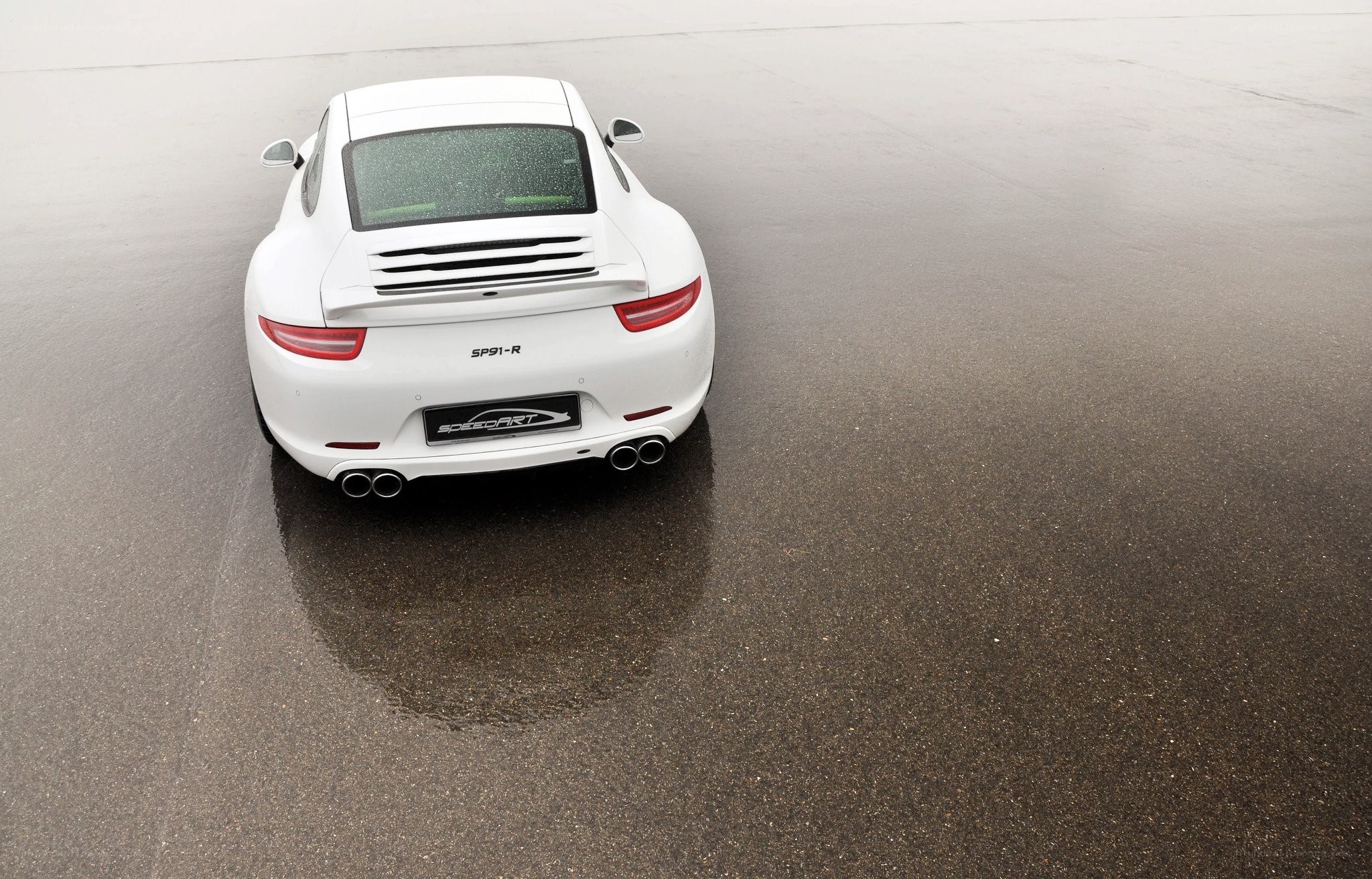 White Porsche on wet pavement