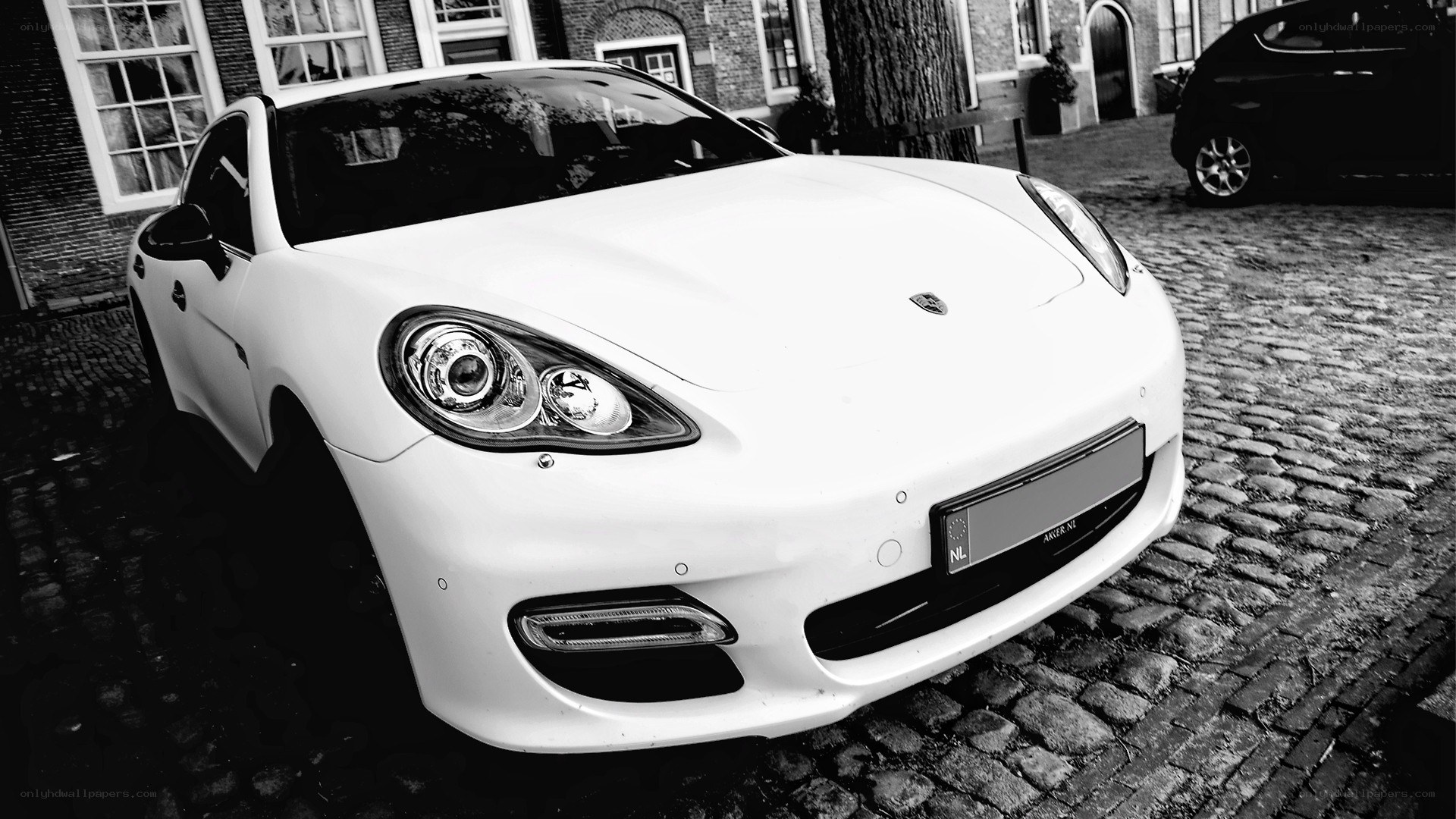 white porsche parked on cobblestones