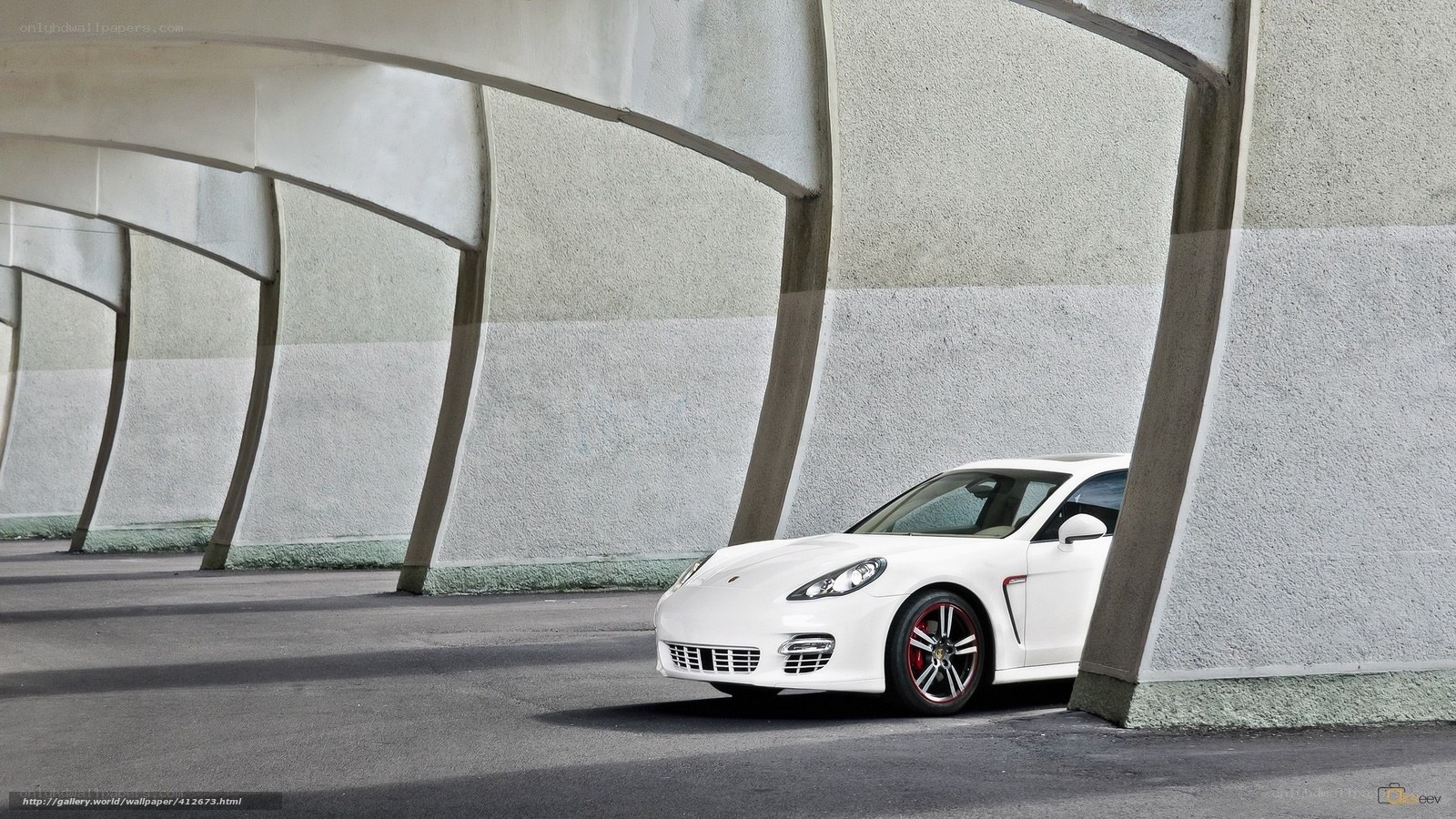 White Porsche parked under arches