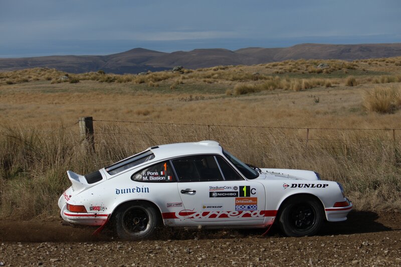 White Porsche rally car on dirt road