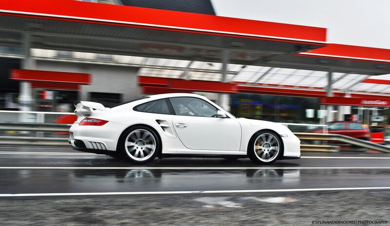 White Porsche speeding past gas station