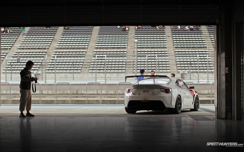 White Race Car in Garage — Dramatic, Photograph, Person with Camera