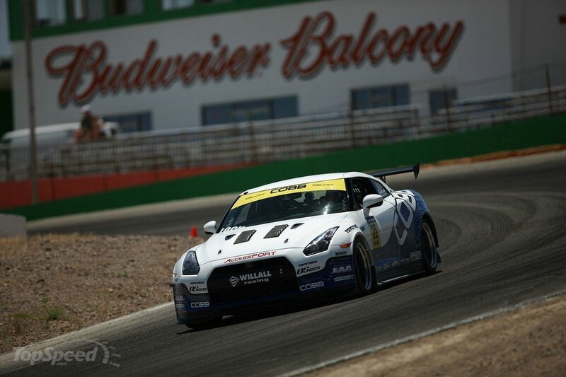 White Race Car on Track — Dynamic, Afternoon, Photograph, Race Car, Building