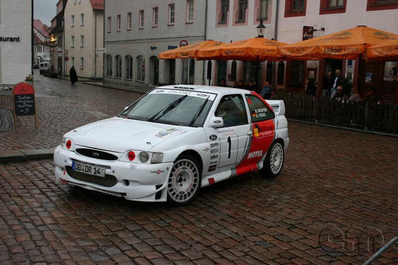 White rally car on cobblestones
