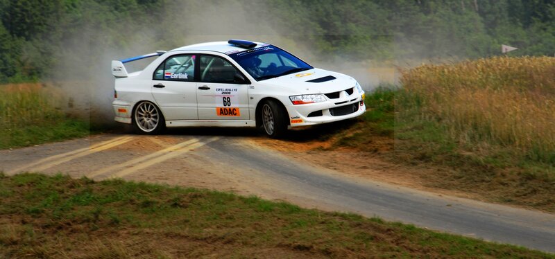 White rally car on dirt road