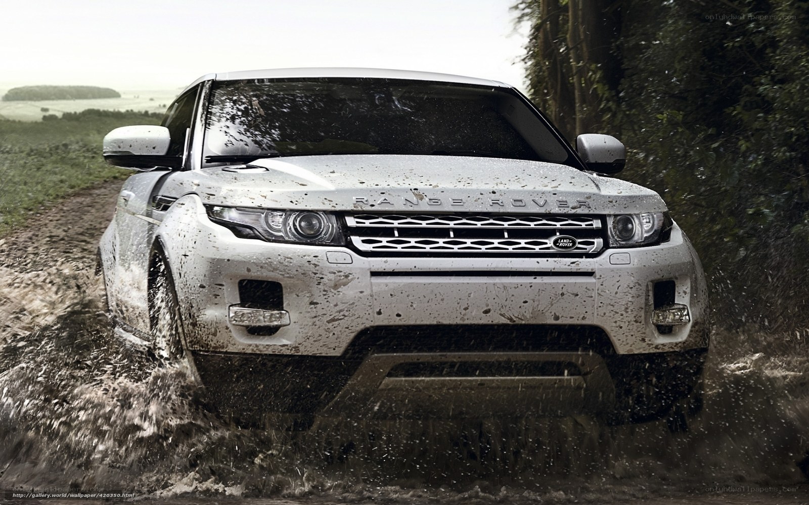 White Range Rover driving through mud