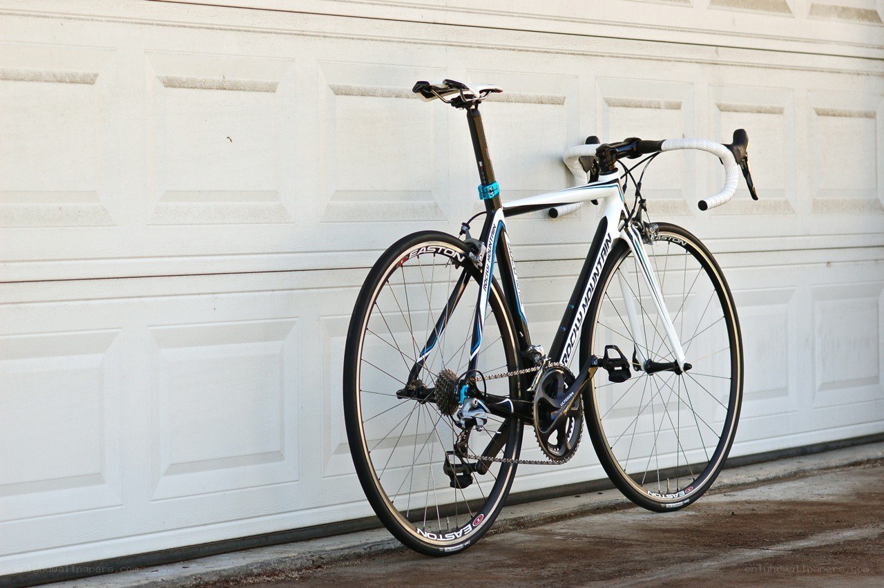 white road bicycle against garage