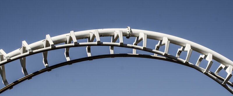 White roller coaster track against blue sky