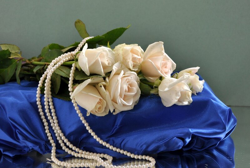 White roses and pearls on blue silk