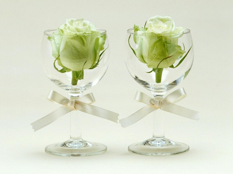white roses in wine glasses