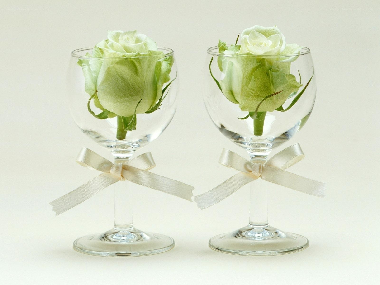 white roses in wine glasses