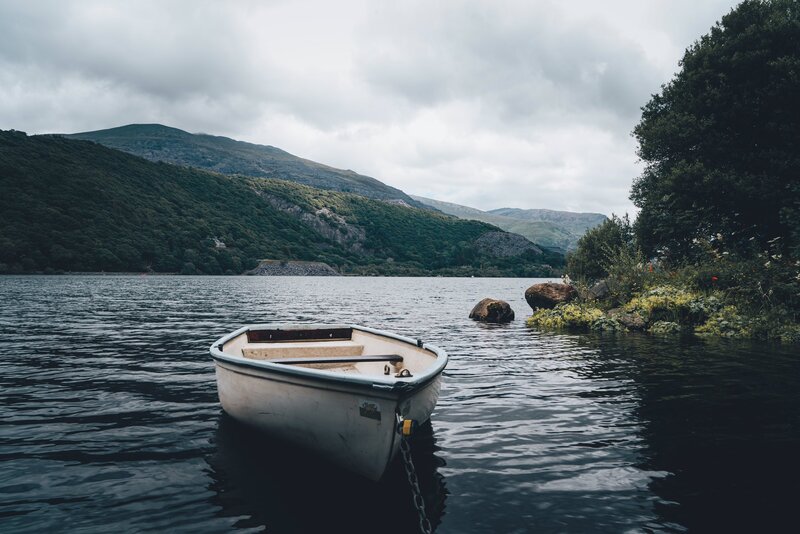 White Rowboat on Lake — Blue