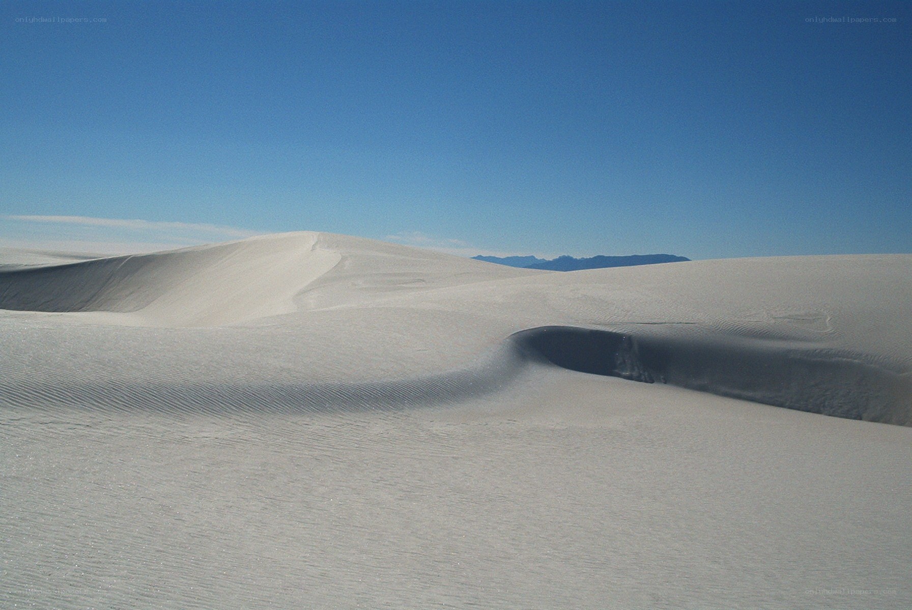 White sand dunes under blue sky