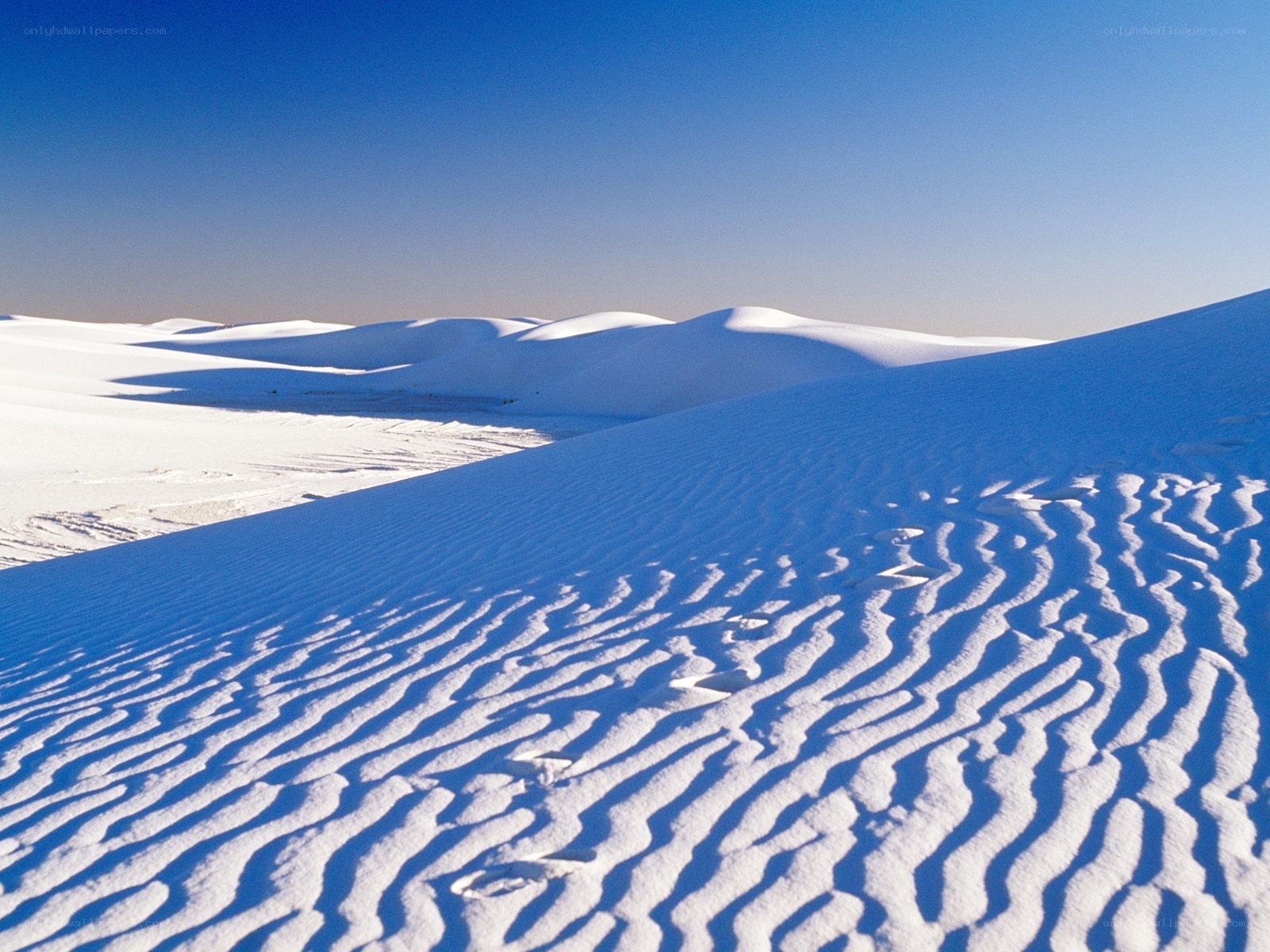 White sand dunes under blue sky