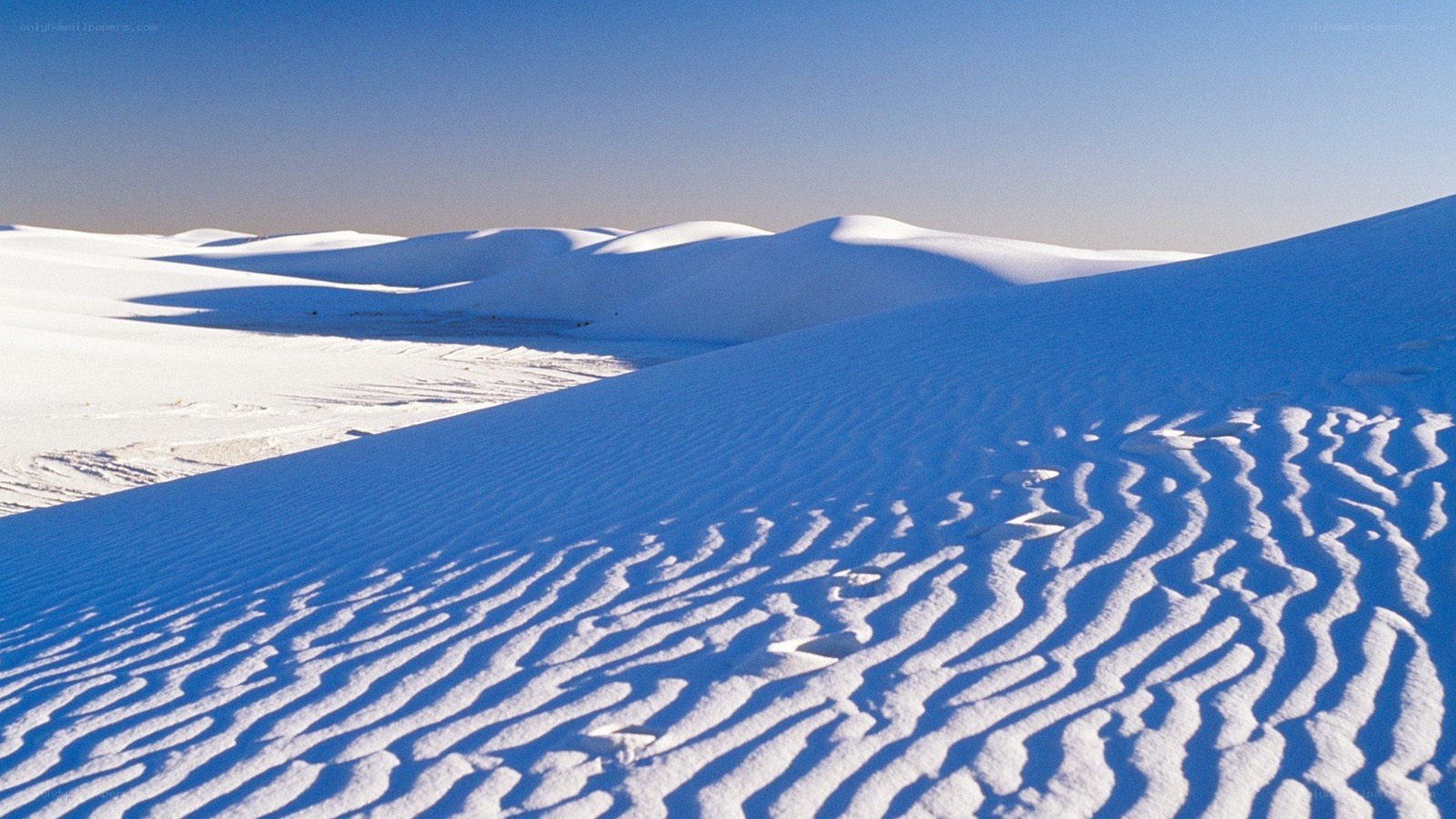 White sand dunes under blue sky