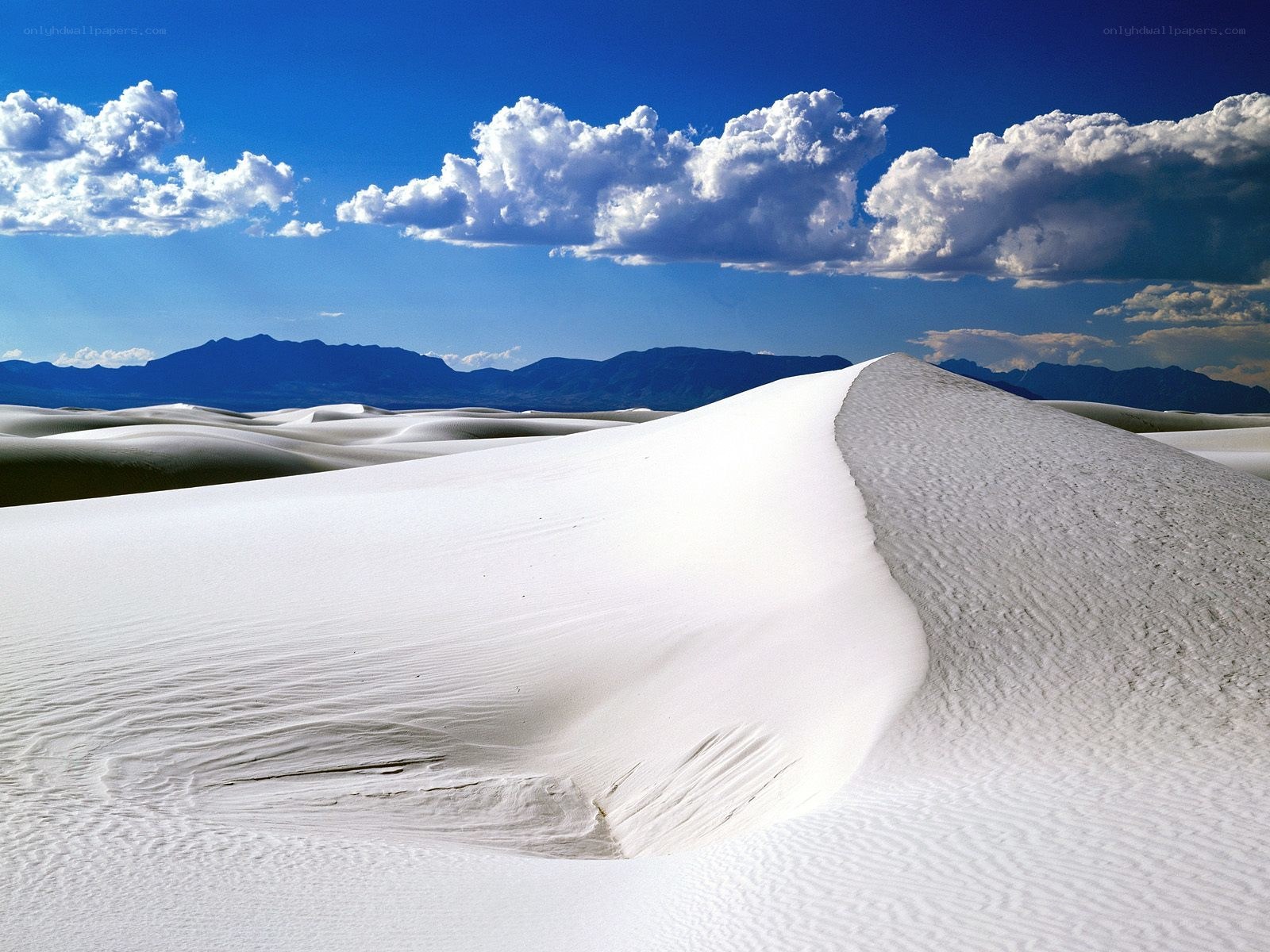 White sand dunes under blue sky