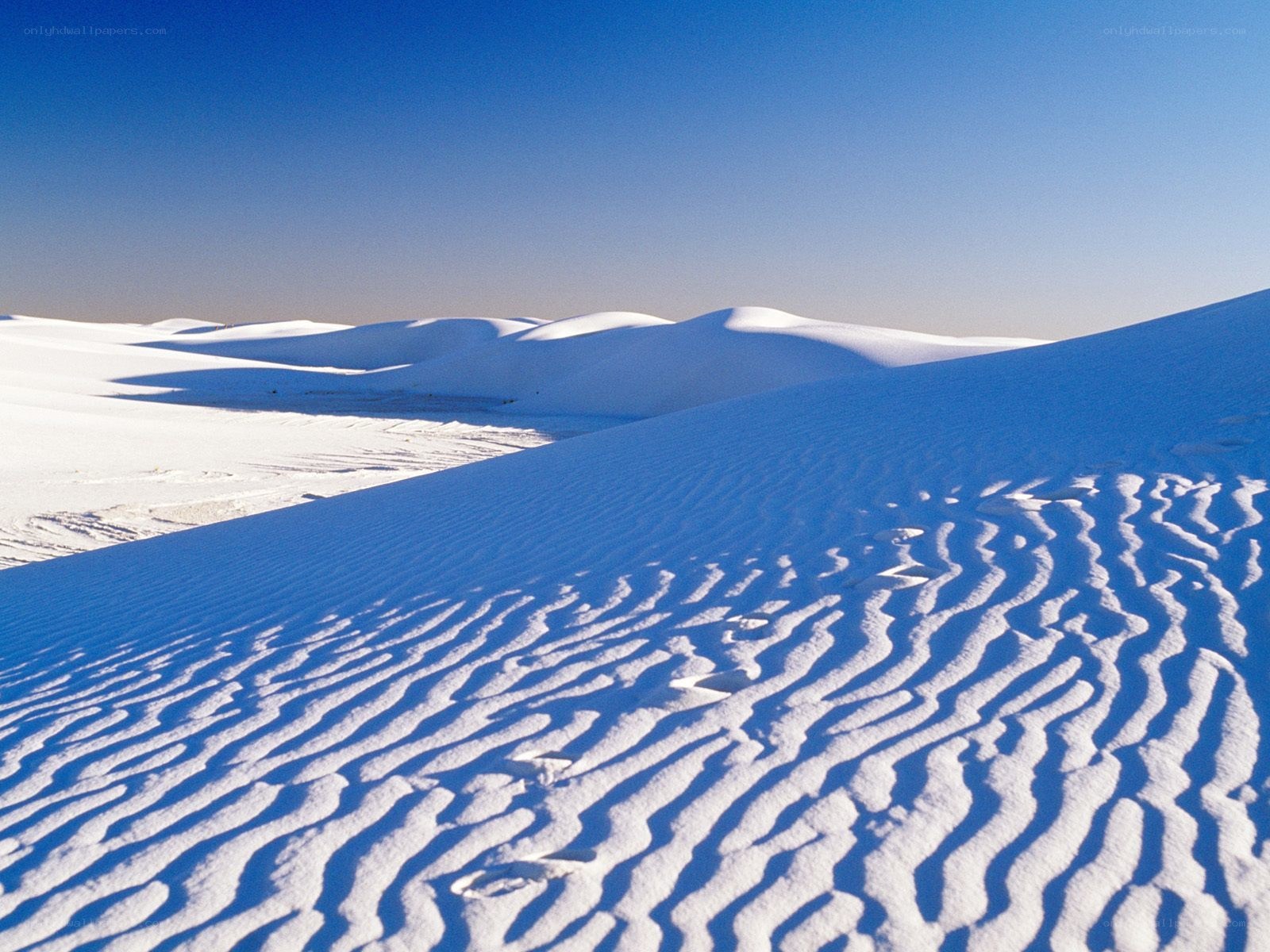 White sand dunes under blue sky