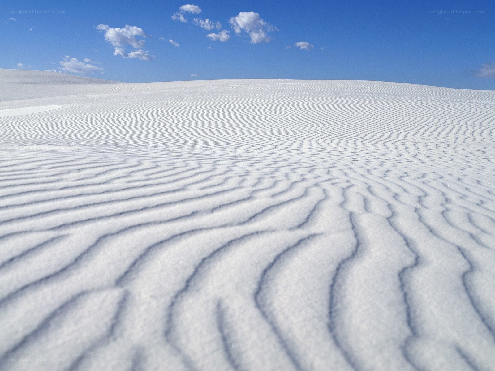 White sand dunes under blue sky