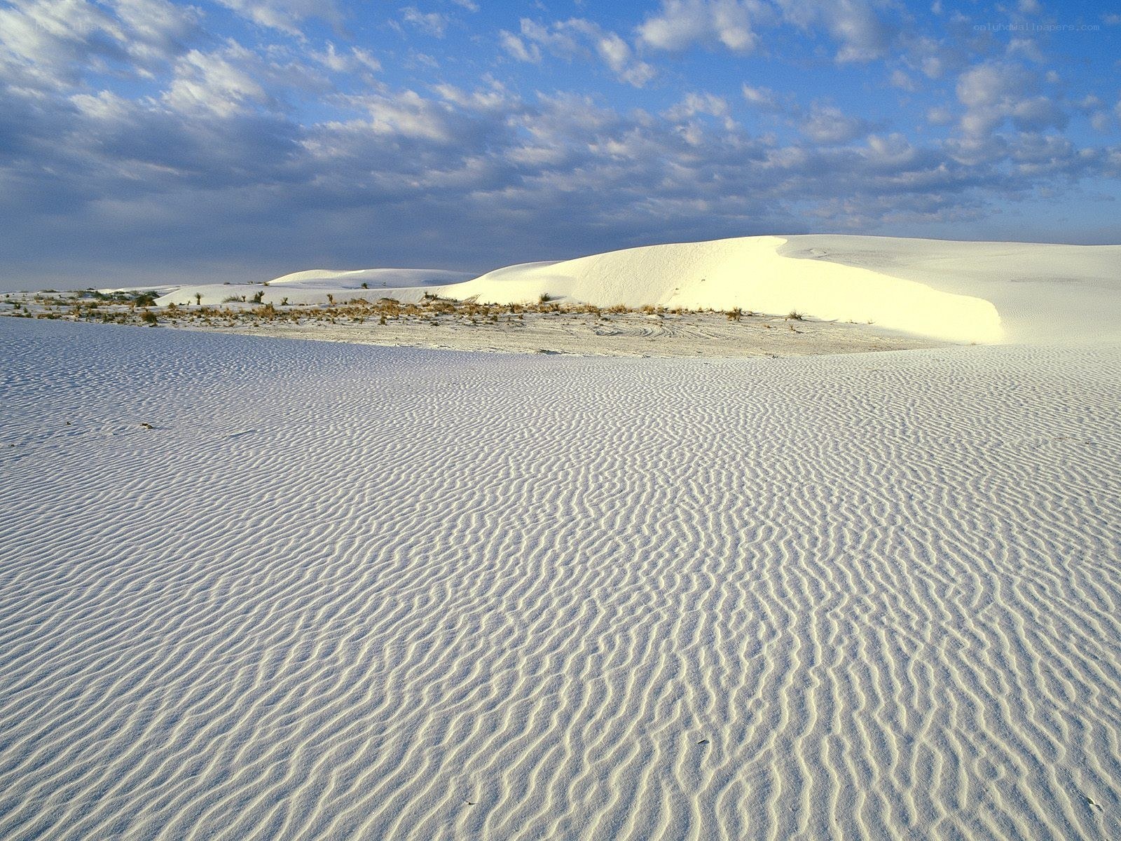 White sand dunes under blue sky