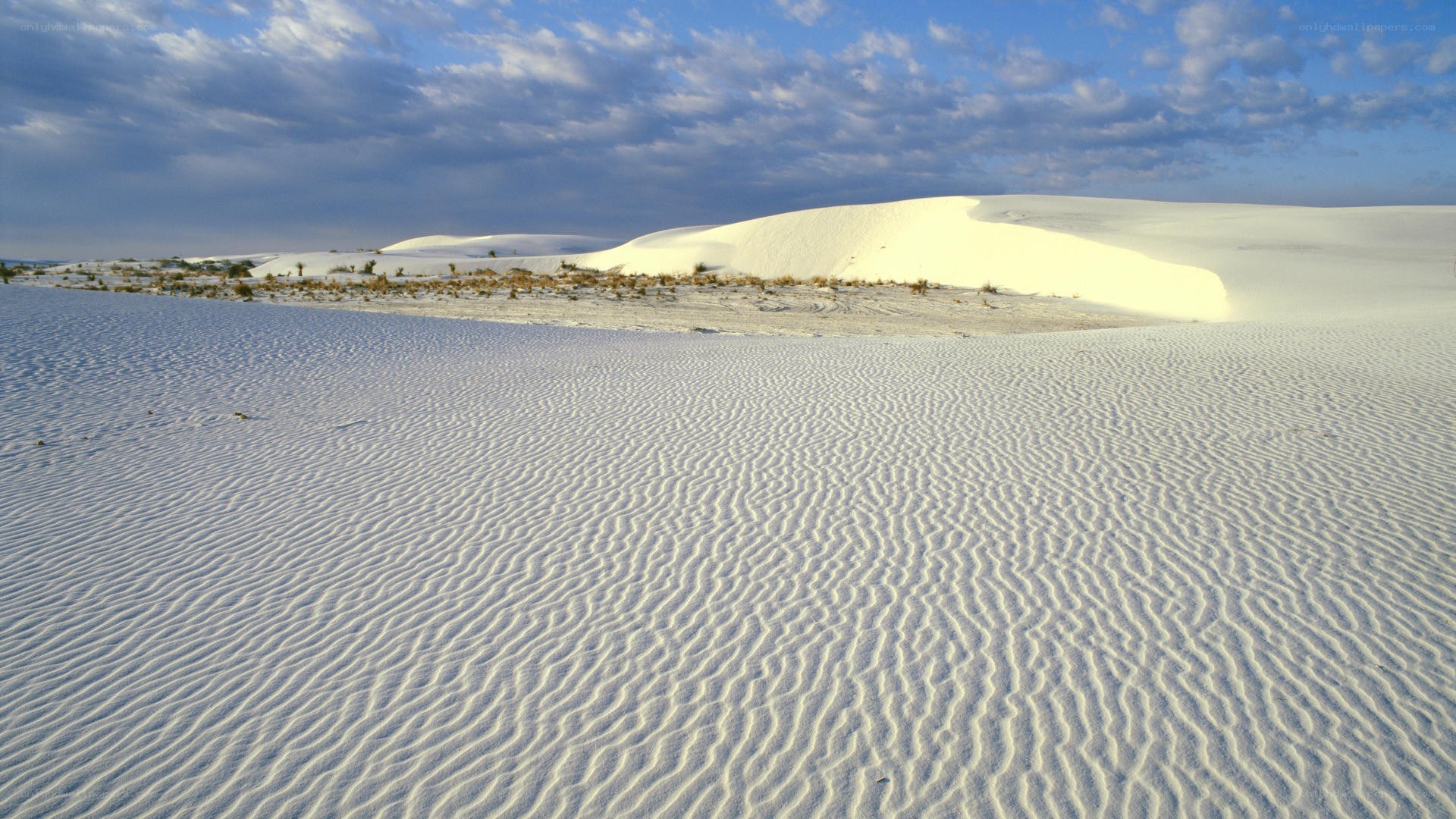 white sand dunes under cloudy sky