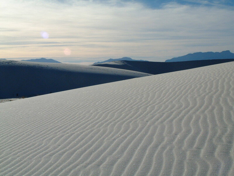 White sand dunes under cloudy sky