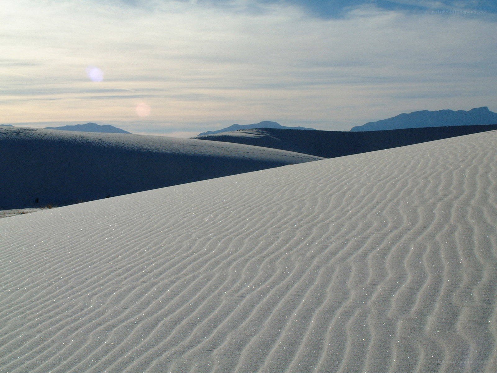 White sand dunes under cloudy sky