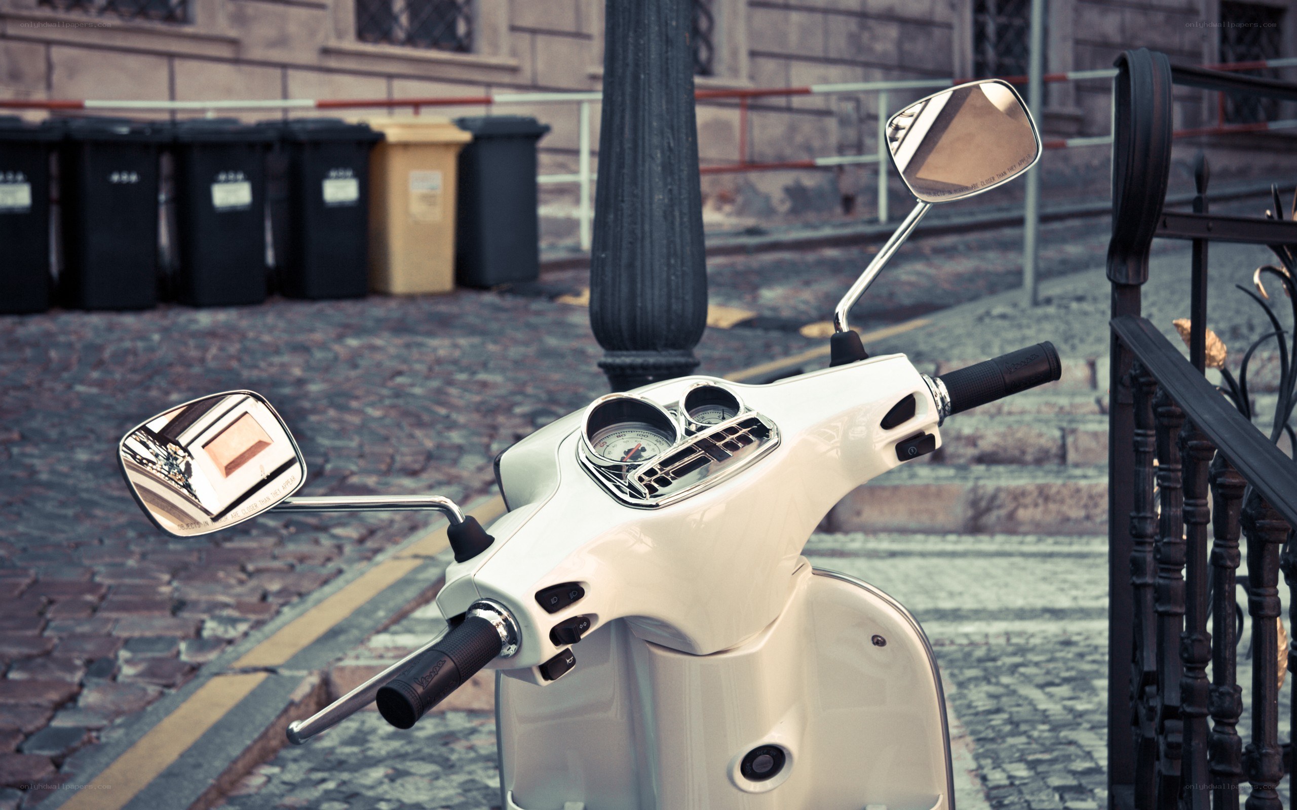 White scooter on cobblestone street