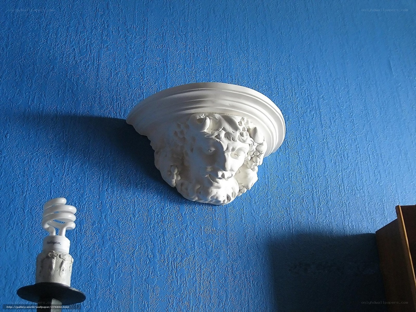 white sculpture on blue wall