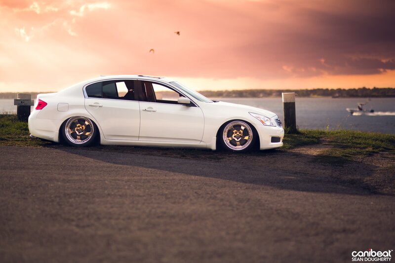 White sedan at sunset by the water