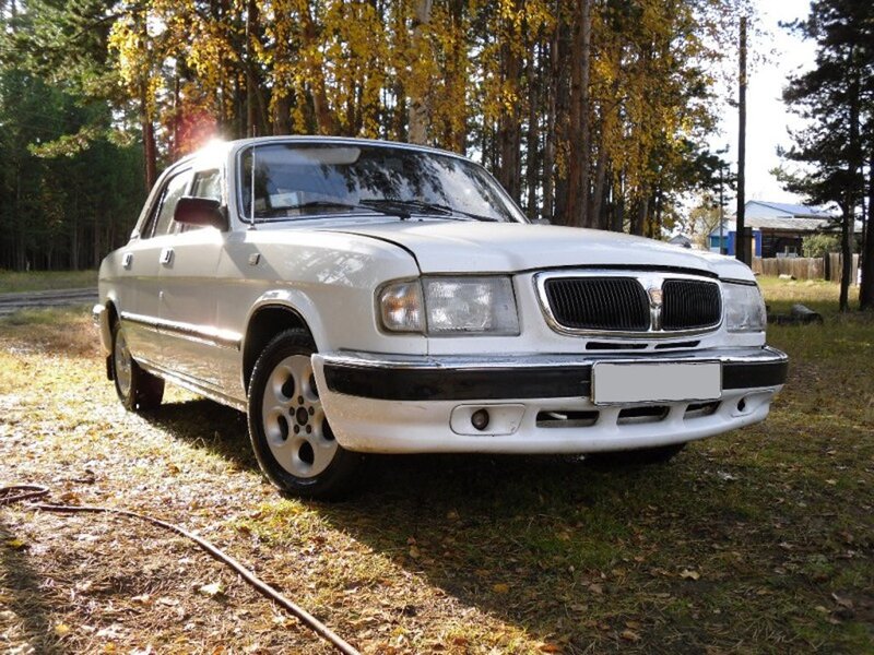 White sedan in autumn forest