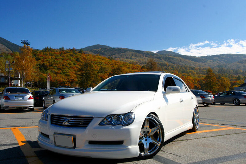 White sedan in autumn parking lot