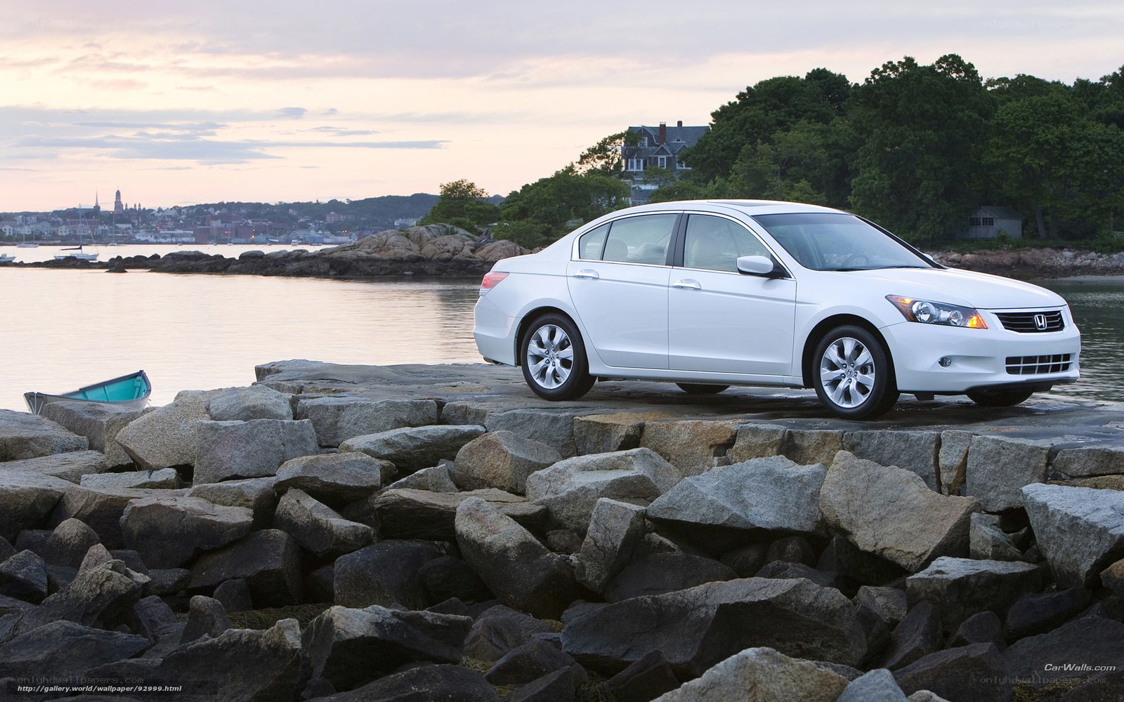 White sedan on rocky shore