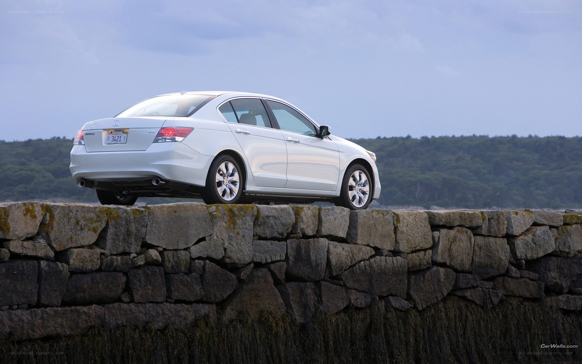 White sedan on stone wall