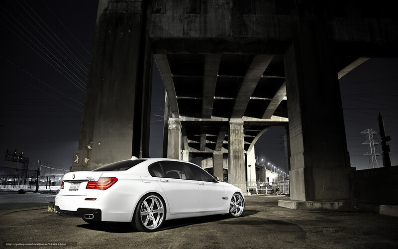 White sedan under highway overpass