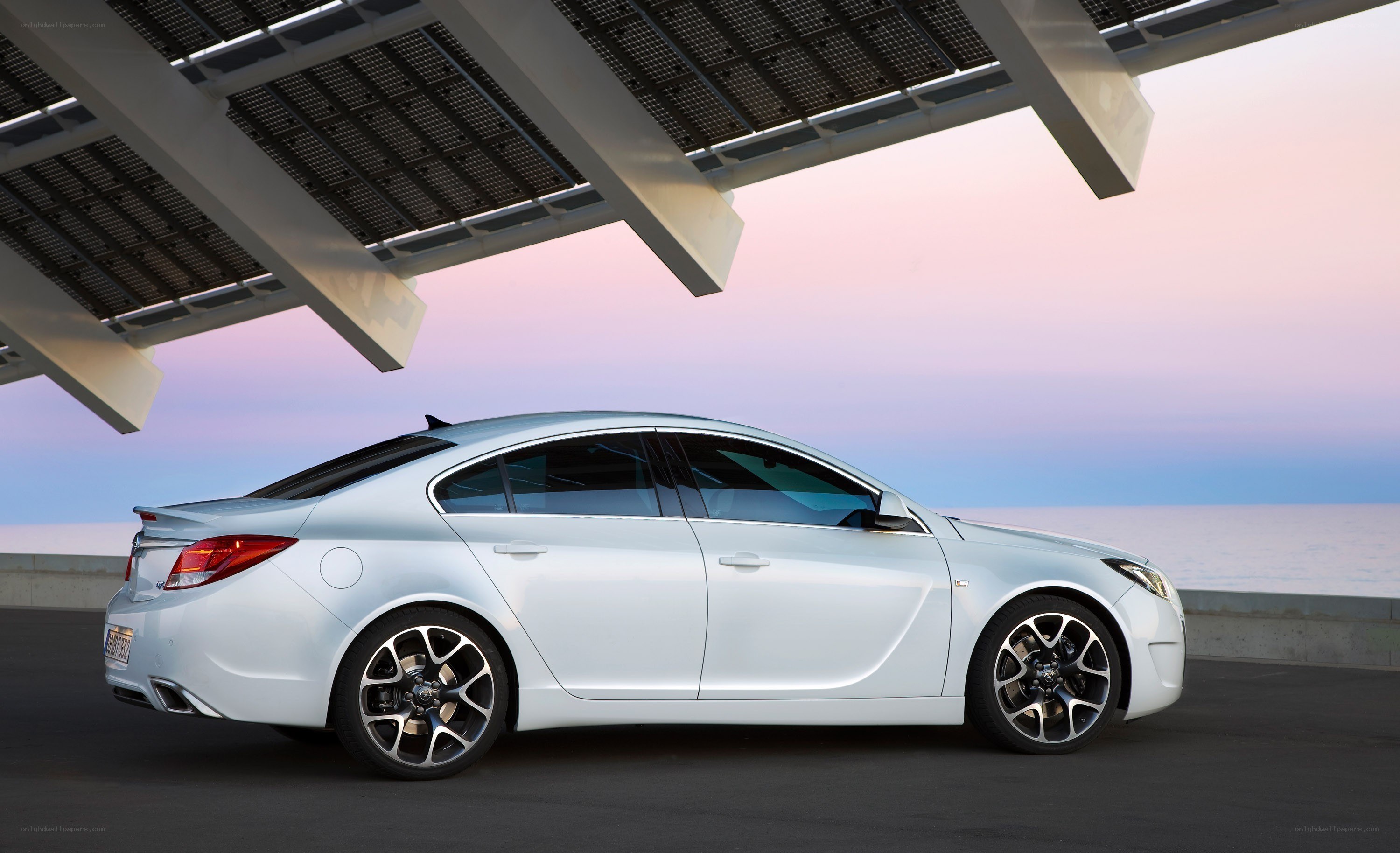 White sedan under solar panels