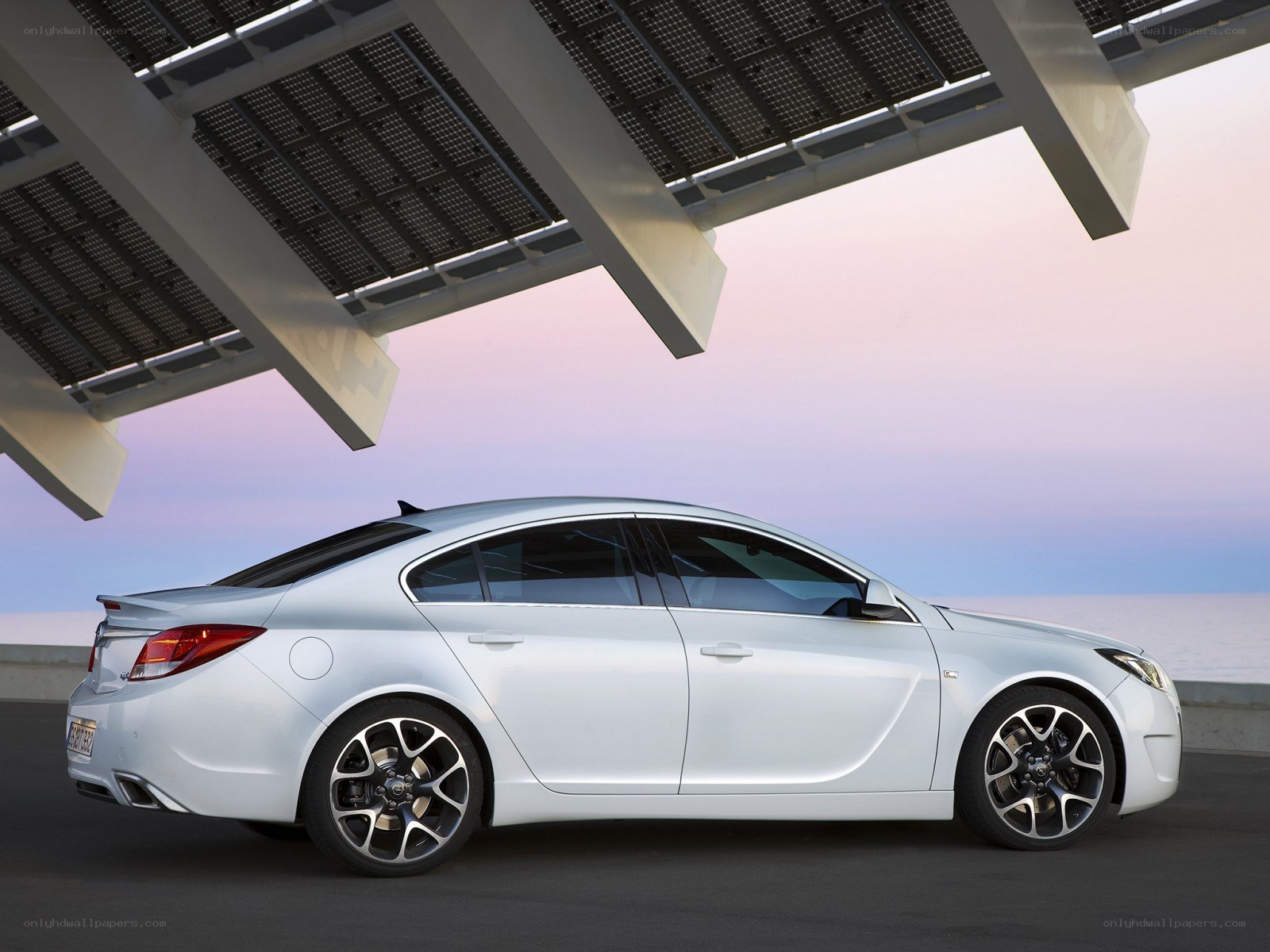 White sedan under solar panels