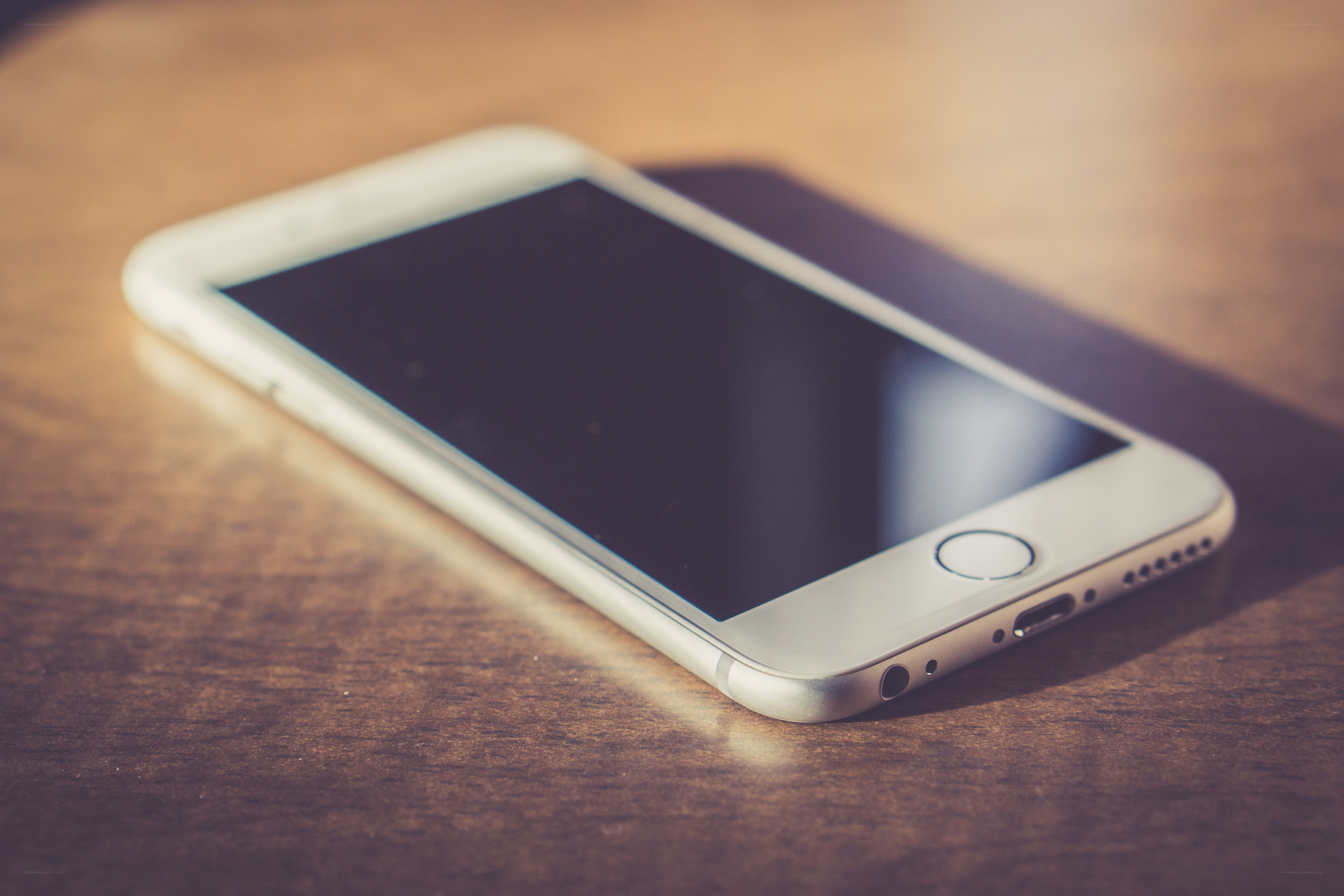 white smartphone on wooden table