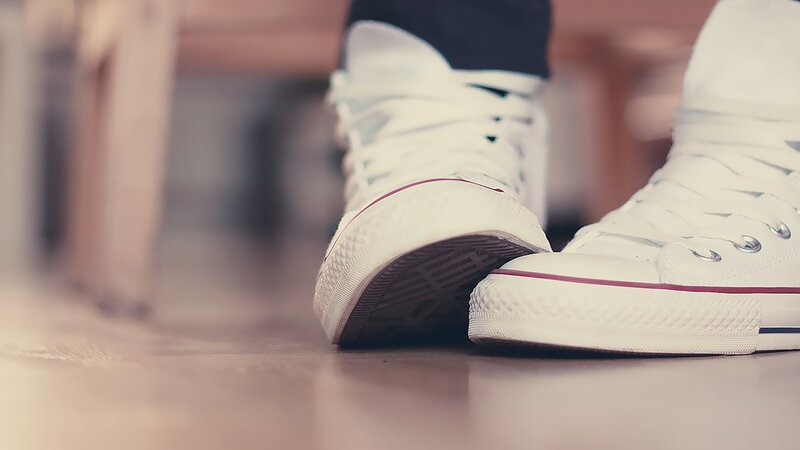 white sneakers on wooden floor