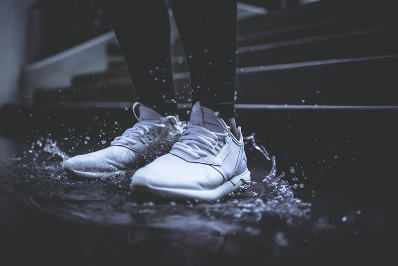 white sneakers splashing water