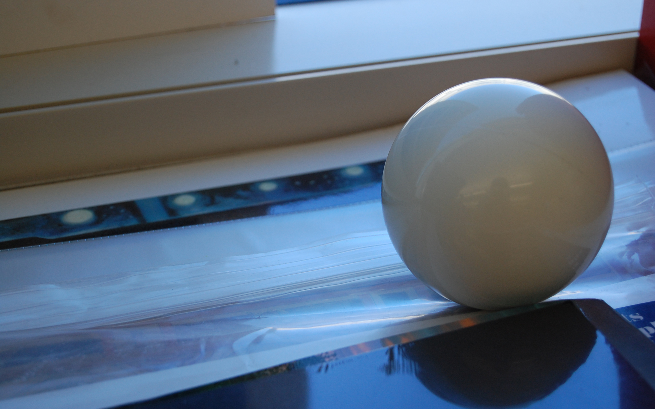 white sphere on glossy surface