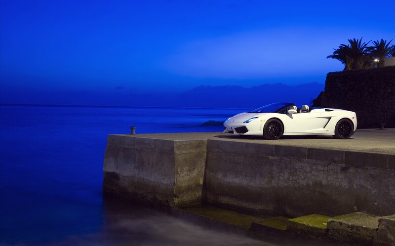 White sports car at dusk by the sea