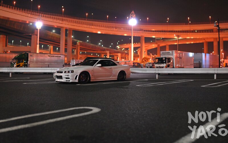 White sports car at night under highway
