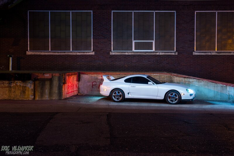 White Sports Car — Dramatic, Night, Photograph, Brick Building, Concrete Wall